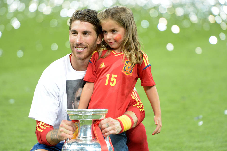 Sergio Ramos holding the trophy poses with his daughter after Spain defeated Italy 4-0